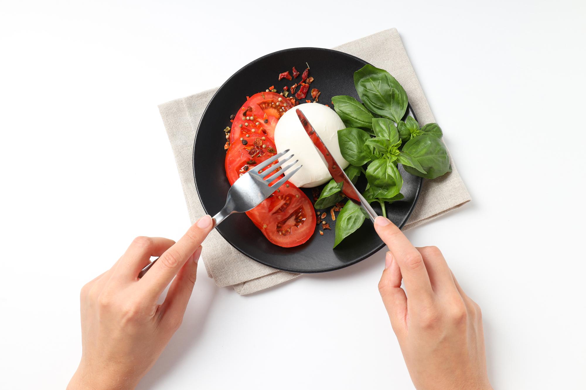 hands plating a composed dish in warm kitchen